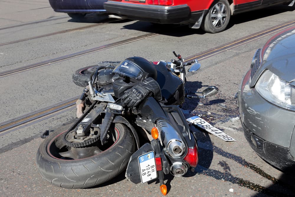 Collision scene: A motorcycle collided with a car, showing the aftermath of the accident.