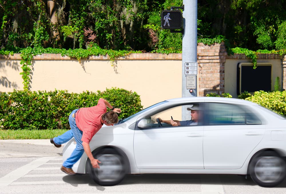 A man that is texting while driving runs over a pedestrian while the Crosswalk